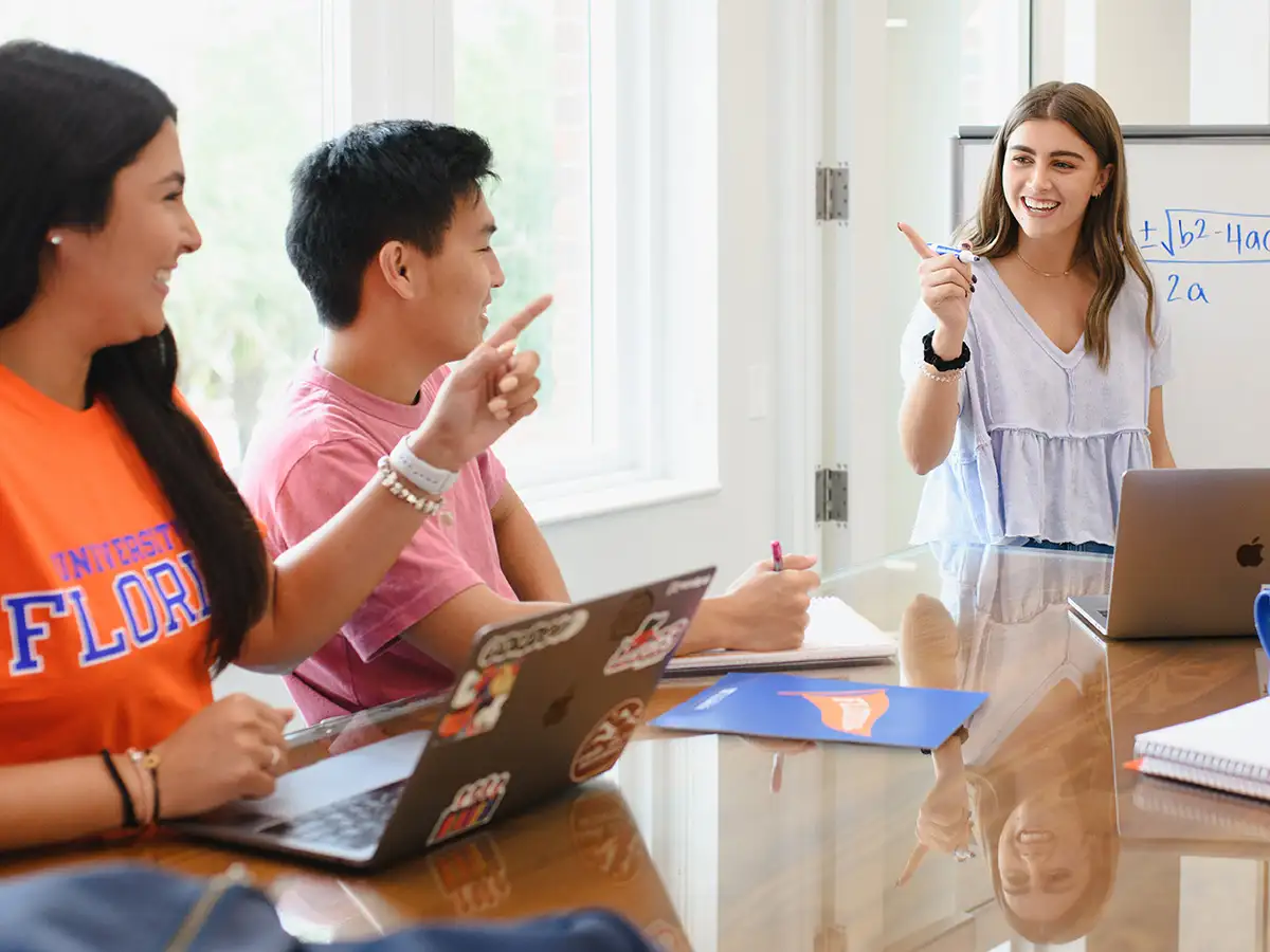 Employee addressing two people sitting at a table